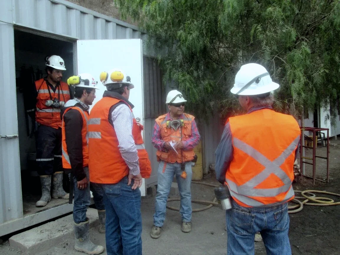 Equipo de trabajo MININGMAQ reunido en terreno con equipo de protección personal