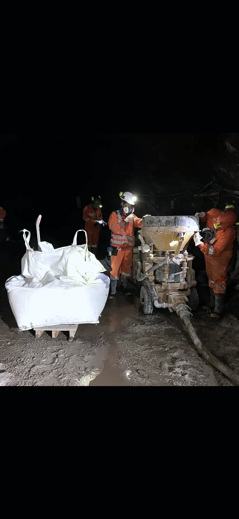 Trabajadores operando equipo de inyección de hormigón en una labor subterránea